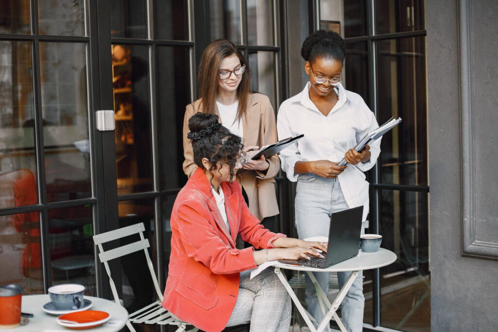 Three businesswomen in the cafe and working with papers and note